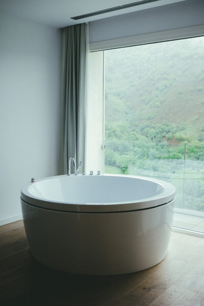 round white soaking tub in large bathroom near picture window