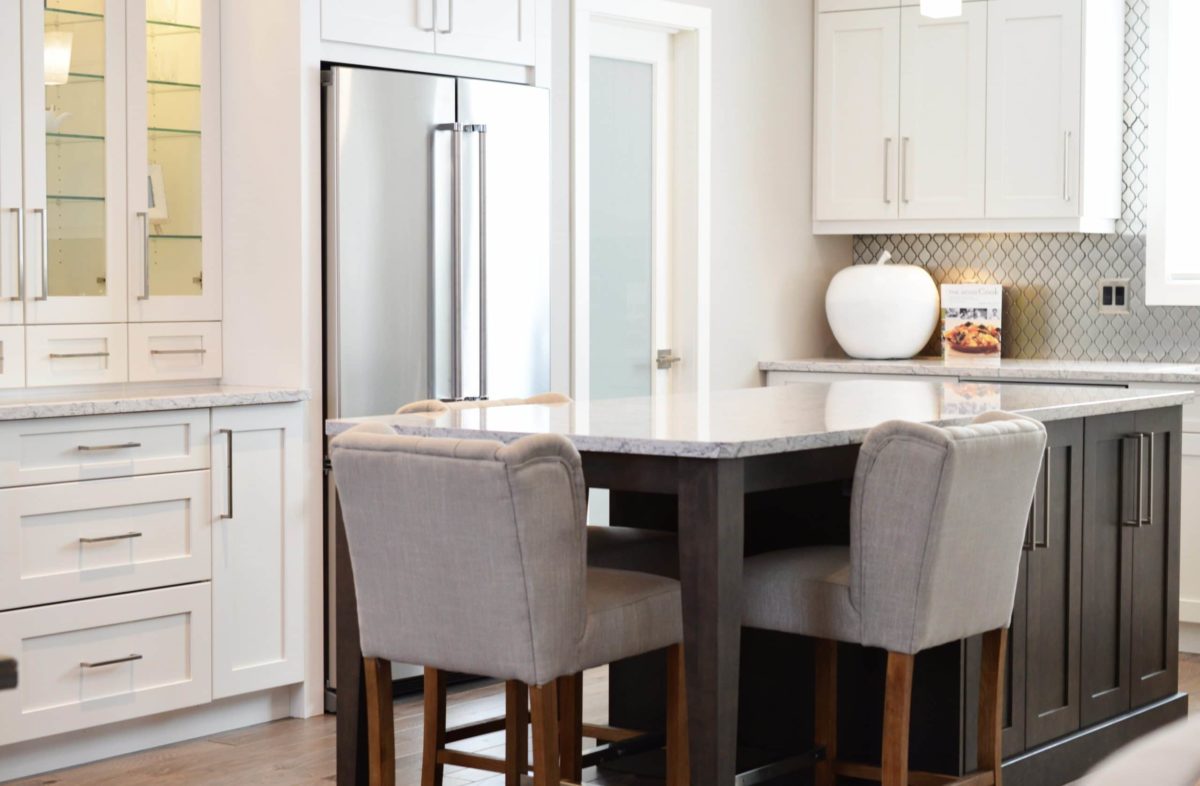 White kitchen cabinets, brown kitchen island, diamond tile backsplash, glass door cabinets, stainless steel fridge kitchen