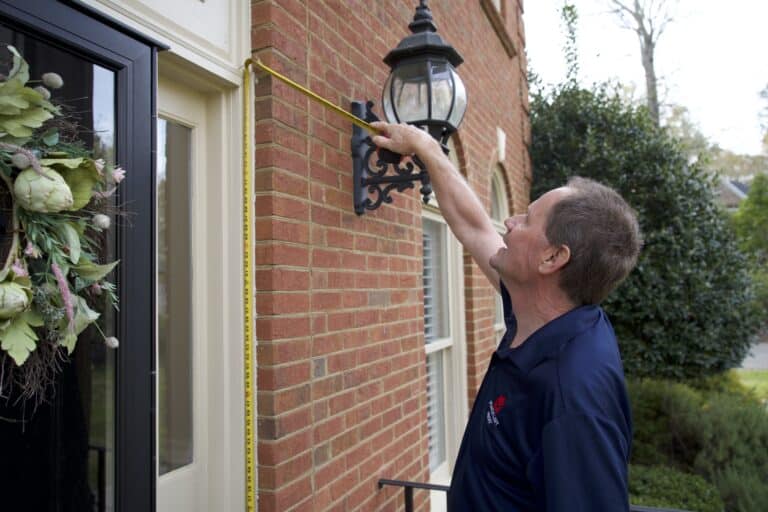 handyman measuring exterior trim
