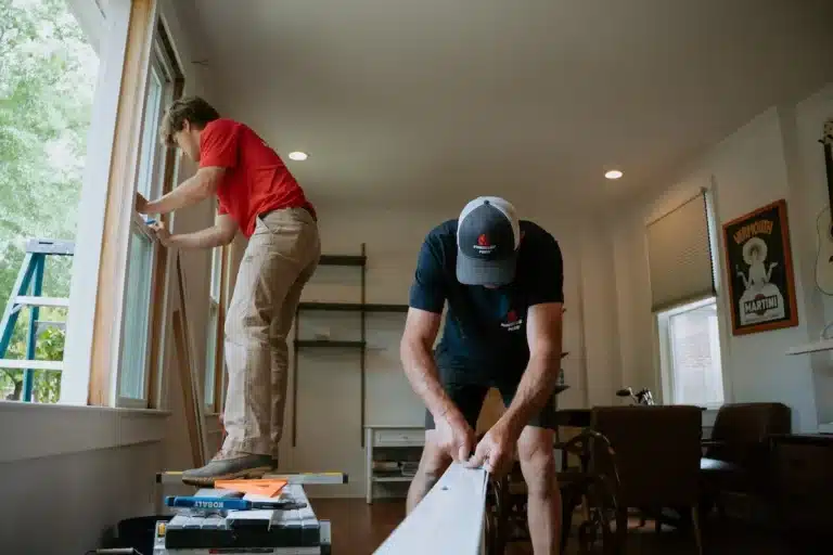 Ceiling Fan Installation 1 Technician installing a ceiling fan in a bedroom, ensuring proper wiring and balanced airflow for year-round comfort.