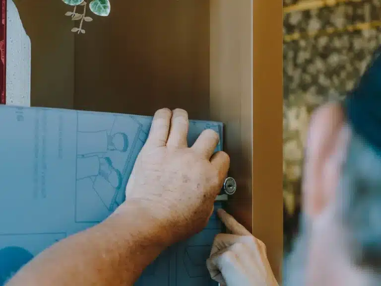 Cabinet Hardware Installation 1 Technician installing cabinet hardware, like handles and knobs, to enhance the kitchen’s functionality and modern look.